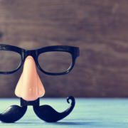 a fake mustache, nose and eyeglasses on a rustic blue wooden surface